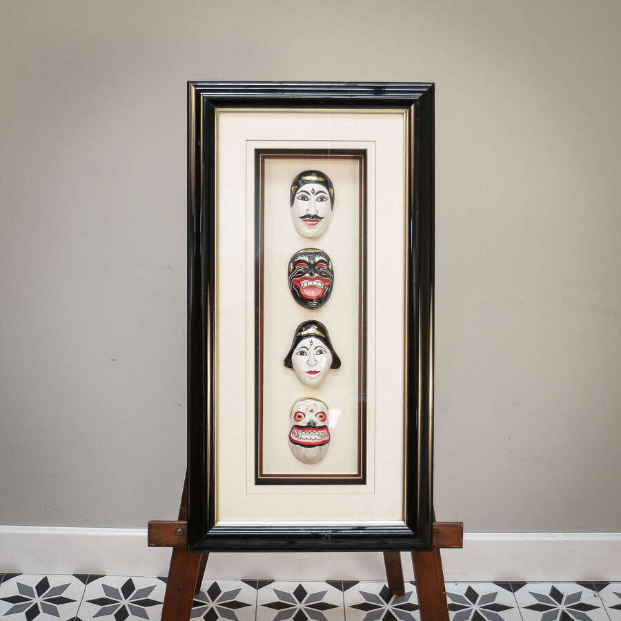 Four Balinese hand painted miniature masks mounted in case.